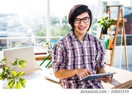 Smiling hipster businessman using tablet Smiling hipster businessman using tablet 20683354