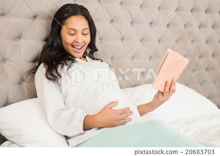Pregnant brunette reading a book Pregnant brunette reading a book 20683703