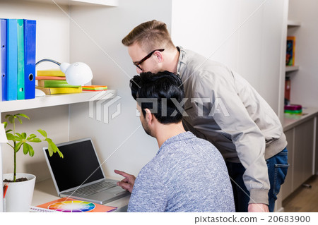 Serious gay couple using laptop 20683900