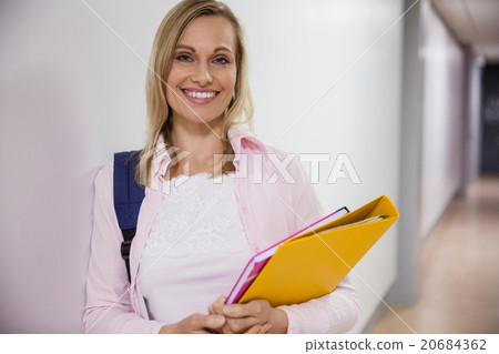 Happy female student walking in the hallway Happy female student walking in the hallway 20684362