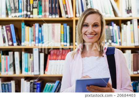 Female student using tablet in library 20684403