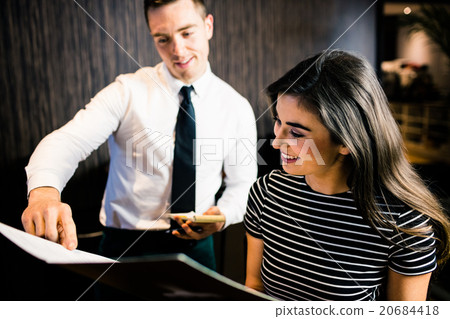 Attractive woman ordering to the waiter from the menu 20684418