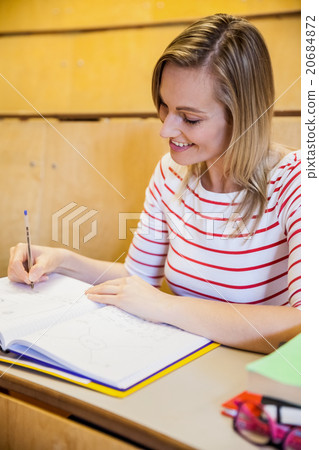 happy female student writing notes 20684872