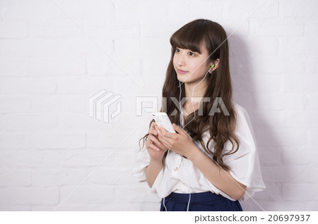 A woman listening to music (white wall) A woman listening to music (white wall) 20697937