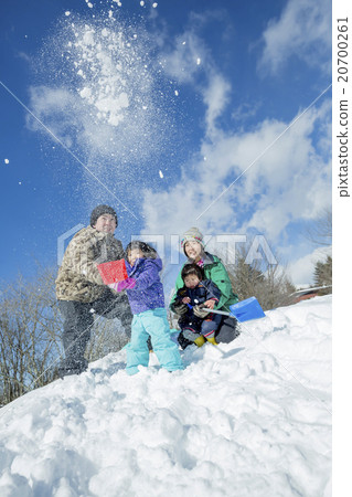 4 people family playing with snow on the snow hill 20700261