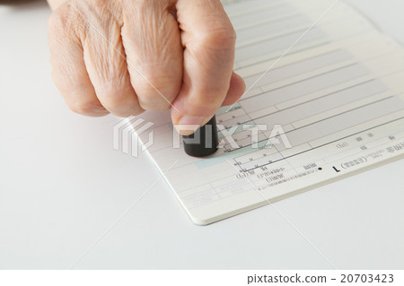 Press a seal on senior women's bank passbook 20703423