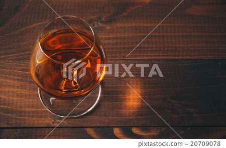 Glass of cognac on the wooden table. 20709078