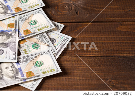 new 100 US dollars bills on wooden background new 100 US dollars bills on wooden background 20709082