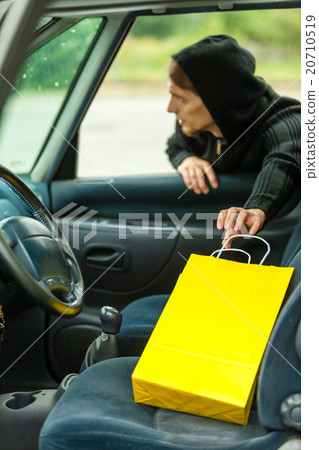 thief stealing shopping bag from the car 20710519