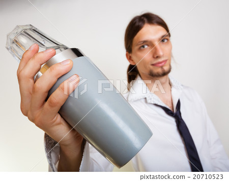 Young man with shaker making cocktail drink 20710523