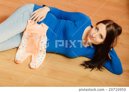 pregnant woman with clothes for unborn baby 20710950