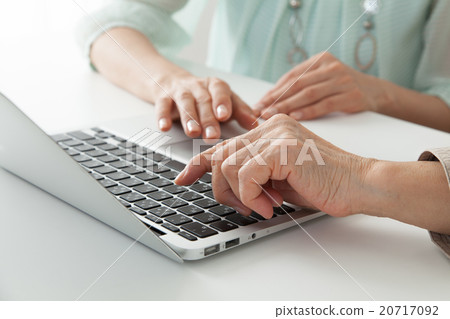 資深婦女和中間女性便攜式計算機和手教訓/教/觀看 20717092