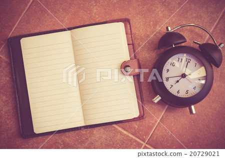 Note book and clock on the floor  20729021
