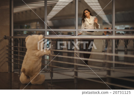 Girl says goodbye with a teddy bear. 20731125