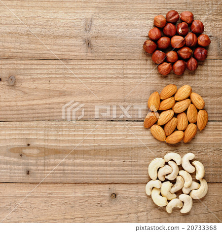 Filberts, almonds and cashew nuts on wooden table 20733368