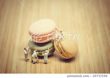 Group of miniature painters coloring macaroon. 20733594