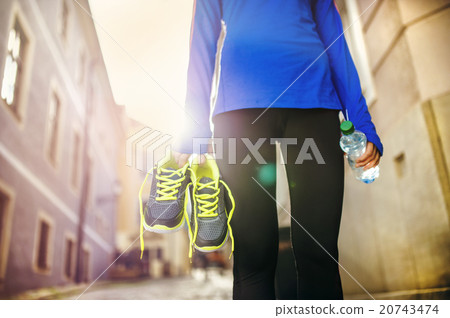 Female runner carrying her shoes 20743474