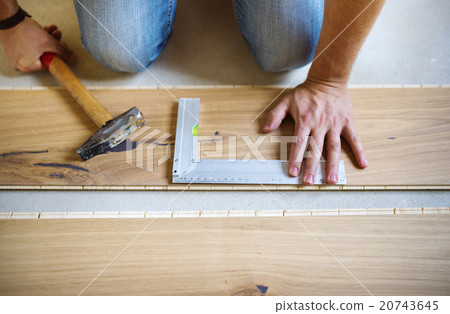 Handyman measuring wooden floor 20743645