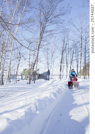 A woman snow removing A woman snow removing 20744887