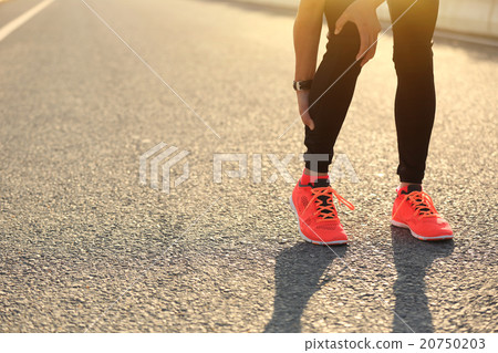 woman runner hold her injured leg on road. woman runner hold her injured leg on road. 20750203