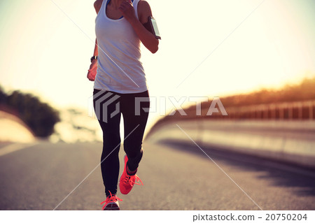young fitness woman runner running on sunrise road young fitness woman runner running on sunrise road 20750204