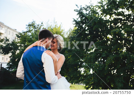 Beautiful wedding couple hugging in the park Beautiful wedding couple hugging in the park 20755750