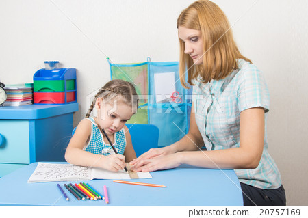 Young girl helps a five-year girl draw a straight line with a ruler Young girl helps a five-year girl draw a straight line with a ruler 20757169
