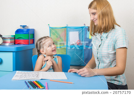 The girl is happy and looks at the teacher in kindergarten The girl is happy and looks at the teacher in kindergarten 20757170