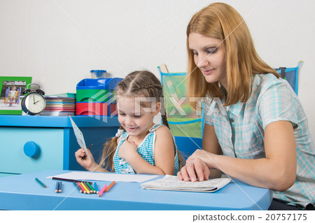 Girl enjoys painting with teacher in kindergarten 20757175