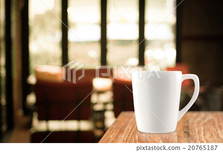 Coffee cup on wood table in blur cafe background 20765187