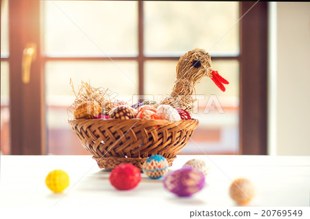Crocheted Easter eggs and straw hen in wicker 20769549