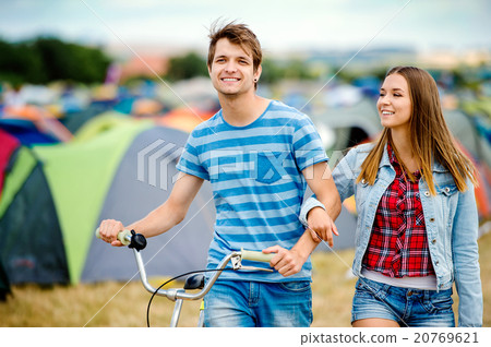 Teenage couple with bike at summer music festival Teenage couple with bike at summer music festival 20769621