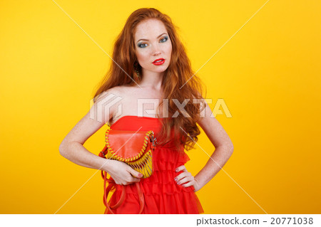 Redheaded pretty girl with orange handbag 20771038