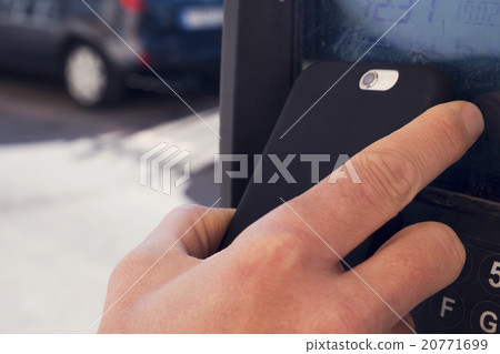 man paying with his smartphone in a parking meter 20771699