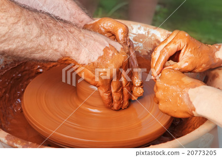 Potter and pupil hands on pottery wheel. 20773205