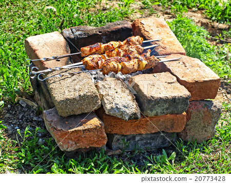Kebab is preparing on barbecue in brick brazier. 20773428