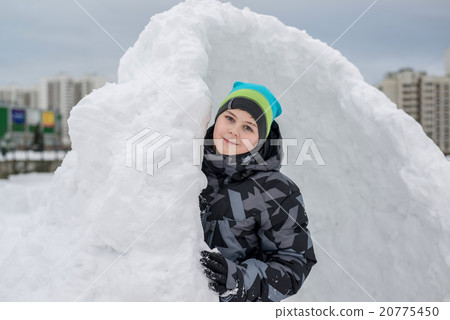 Teen boy standing in makeshift snow fort Teen boy standing in makeshift snow fort 20775450