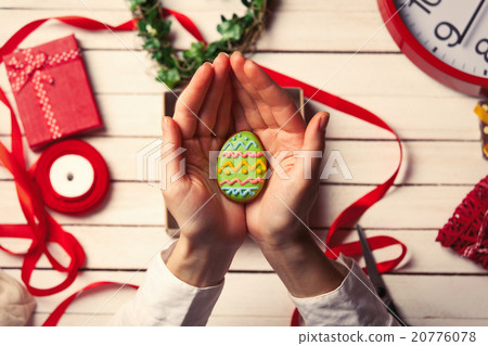 Female hands are holding Easter cookie 20776078