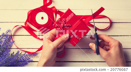 female hands holding a gift and scissors 20776087