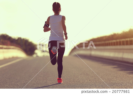 young fitness woman runner running on sunrise road 20777981