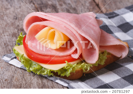 Tasty sandwich of ham and cheese on old desk 20781297