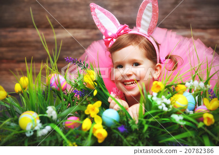 Happy child girl in  costume Easter bunny rabbit on grass and fl 20782386