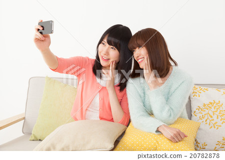 A woman taking a picture with her friends 20782878