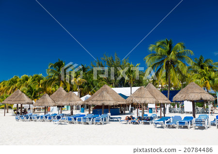 Caribbean beach with sun umbrellas and bed 20784486