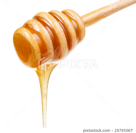 clear honey flows down from wooden stick close up 20785067