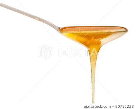 clear honey flows down from metal spoon close up 20785228