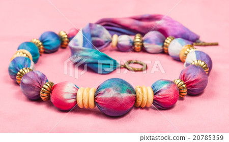 necklace from silk balls and bone rings on pink 20785359