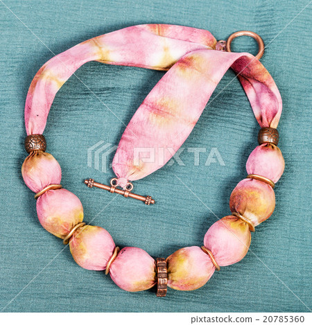 top view of necklace from pink silk balls on green 20785360
