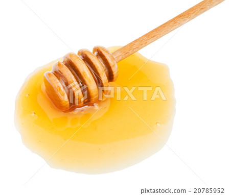 puddle of transparent honey and stick close up 20785952