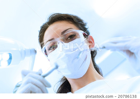 Dentist in mask holding angled mirror and drill Dentist in mask holding angled mirror and drill 20786138